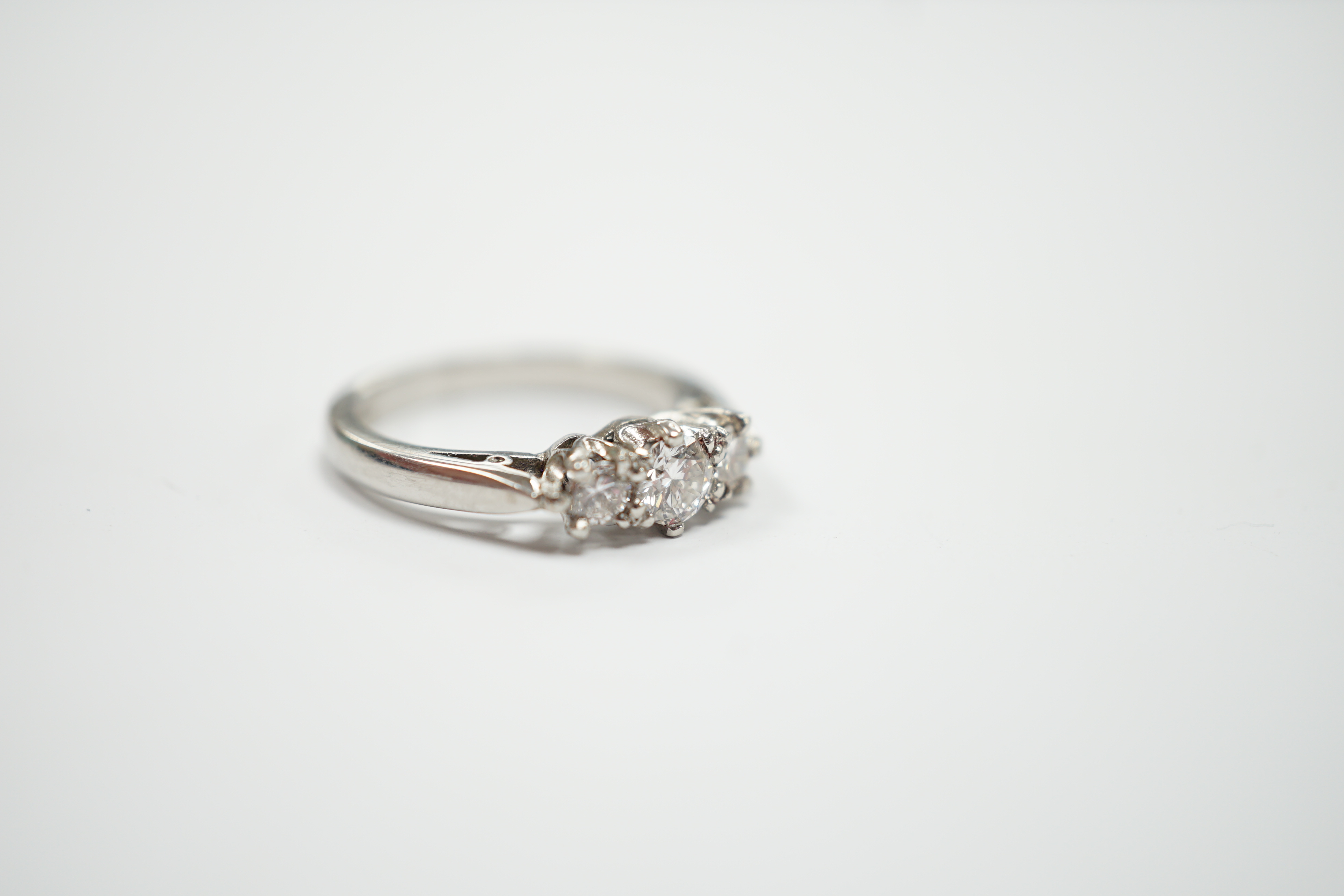 A modern platinum and three stone diamond set ring, size J, gross weight 4.6 grams.